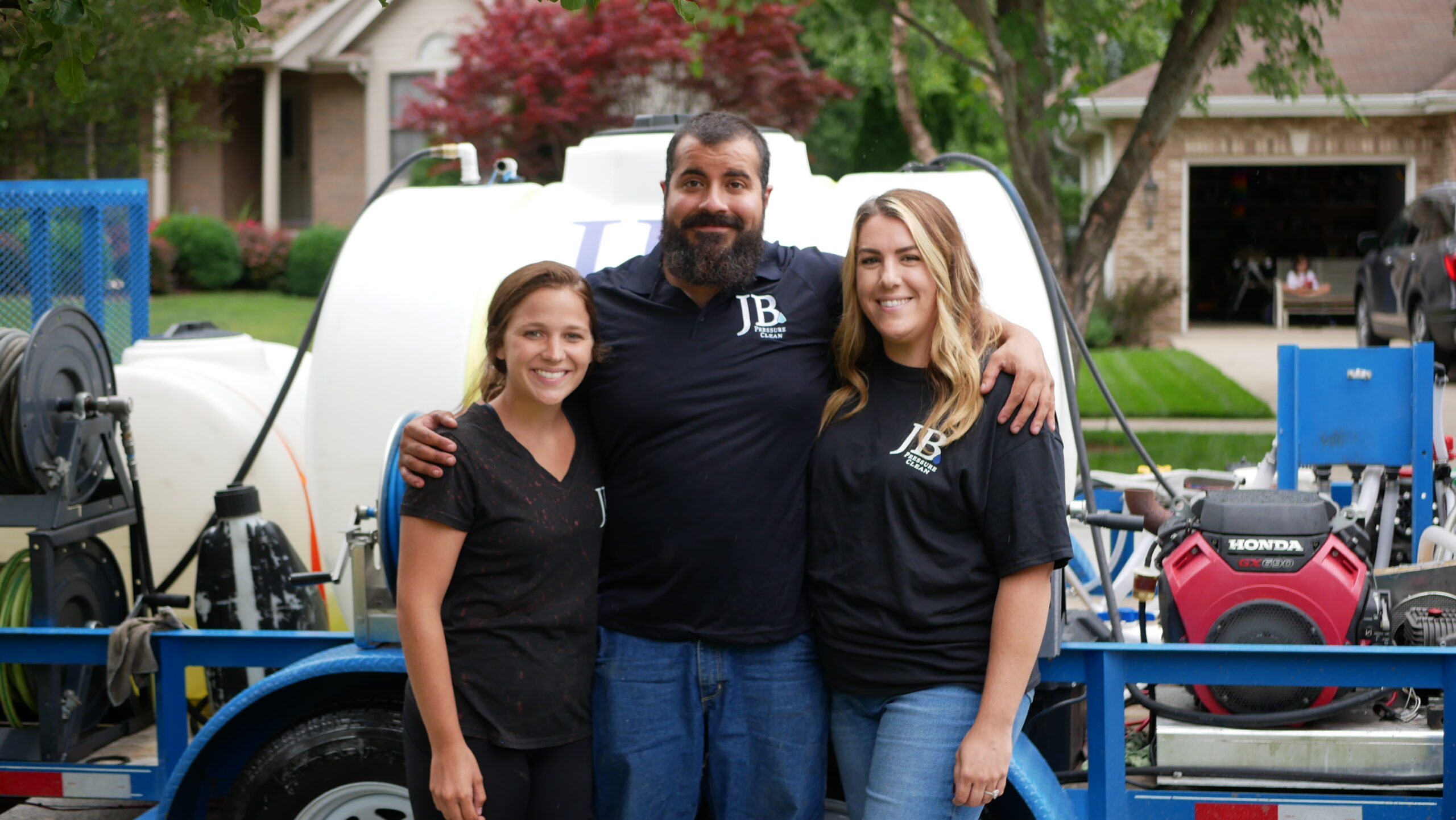 About Us Photo of Owners and Employee of JB Pressure Clean standing in front of water tank